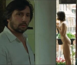Lewd Vimala Pons is watched by man smoking on balcony in J'aurais Pu être Une Pute